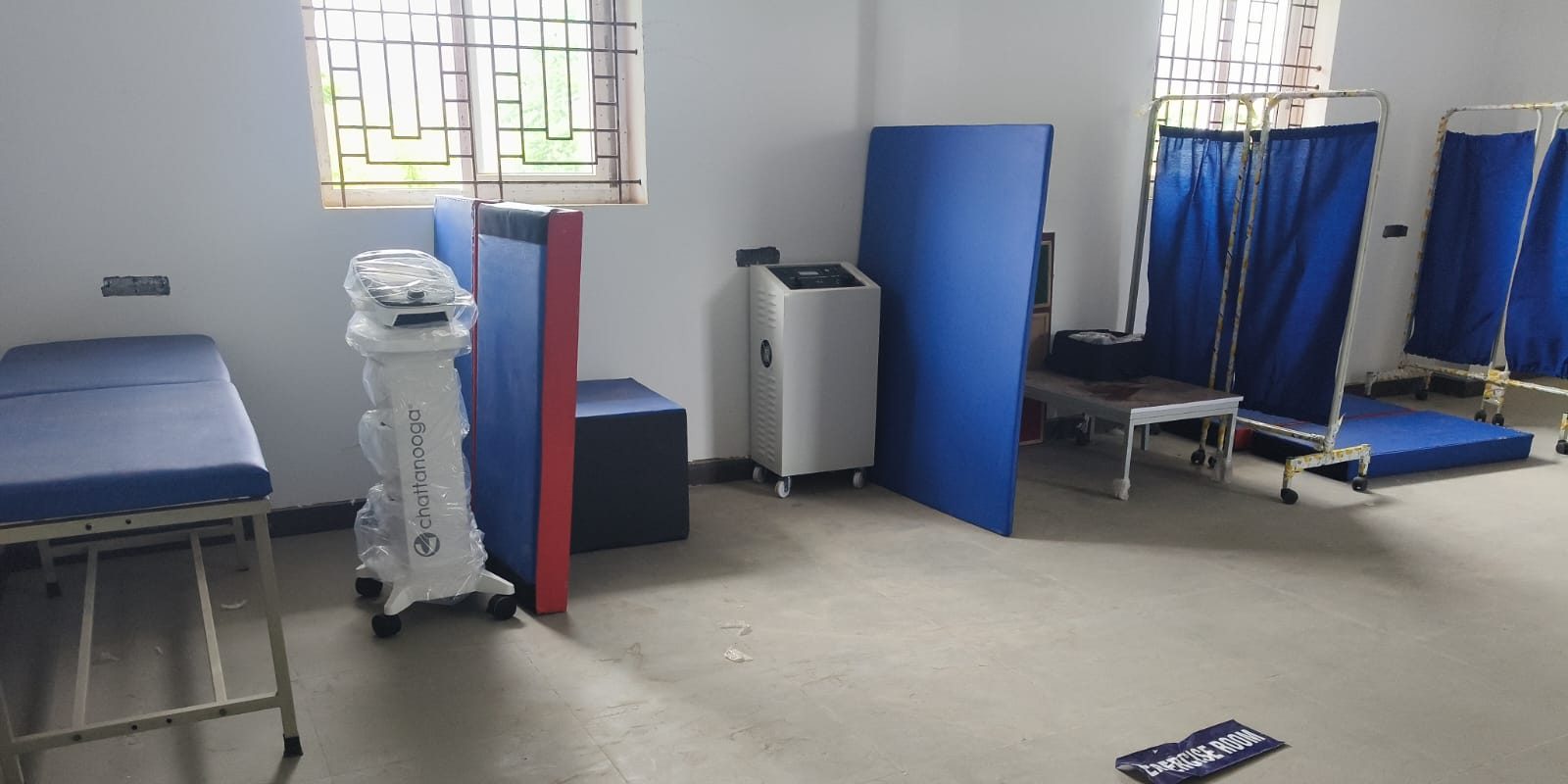 Exercise therapy and electrotherapy lab with treatment couch, electrotherapy units, exercise mats and privacy screens