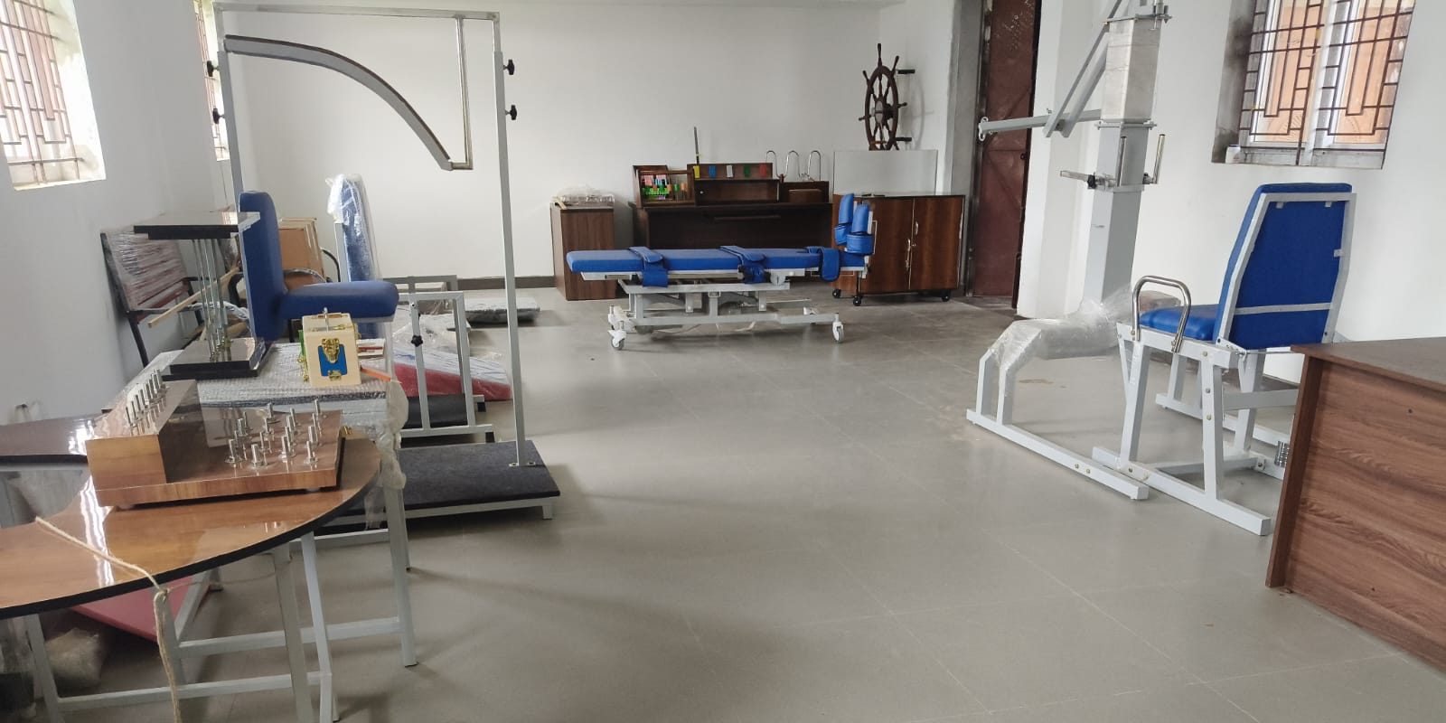 Rehabilitation lab with tilt table, shoulder wheel, quadriceps chair, overhead pulley frame and hand-function boards